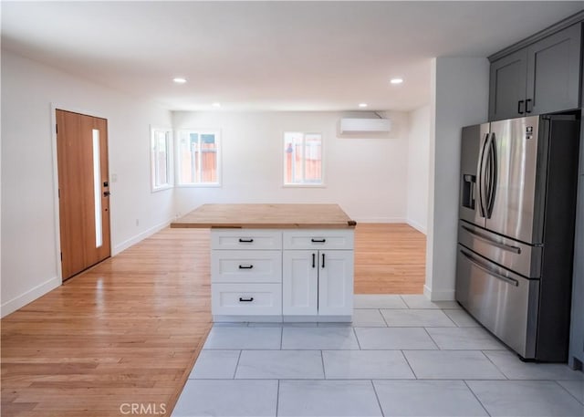1522 N Benton Way, Los Angeles, CA 90026 - kitchen featuring stainless steel refrigerator with ice dispenser, a wall unit AC, wood counters, baseboards, and light wood finished floors