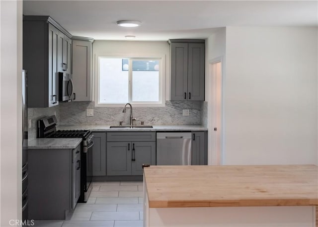 1522 N Benton Way, Los Angeles, CA 90026 - kitchen featuring stainless steel appliances, a sink, gray cabinetry, and backsplash