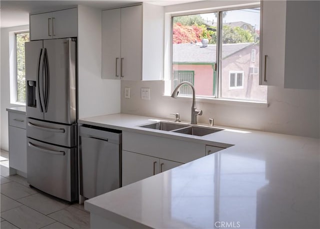 1522 N Benton Way, Los Angeles, CA 90026 - kitchen with appliances with stainless steel finishes, a sink, light countertops, backsplash, and white cabinets