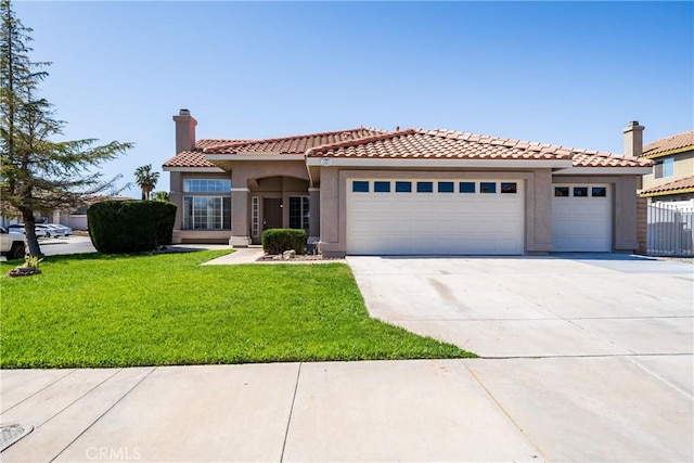 13073 San Dimas Cir, Victorville, CA 92392 - mediterranean / spanish house featuring a garage, stucco siding, concrete driveway, and a front yard