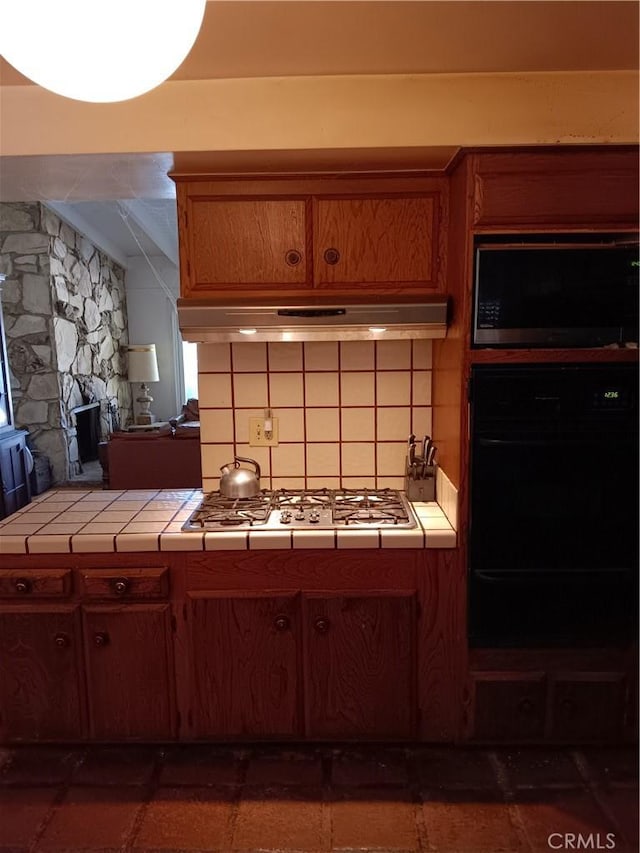 4301 Manson Ave, Woodland Hills, CA 91364 - kitchen with tile countertops, stainless steel gas cooktop, black microwave, decorative backsplash, and brown cabinetry