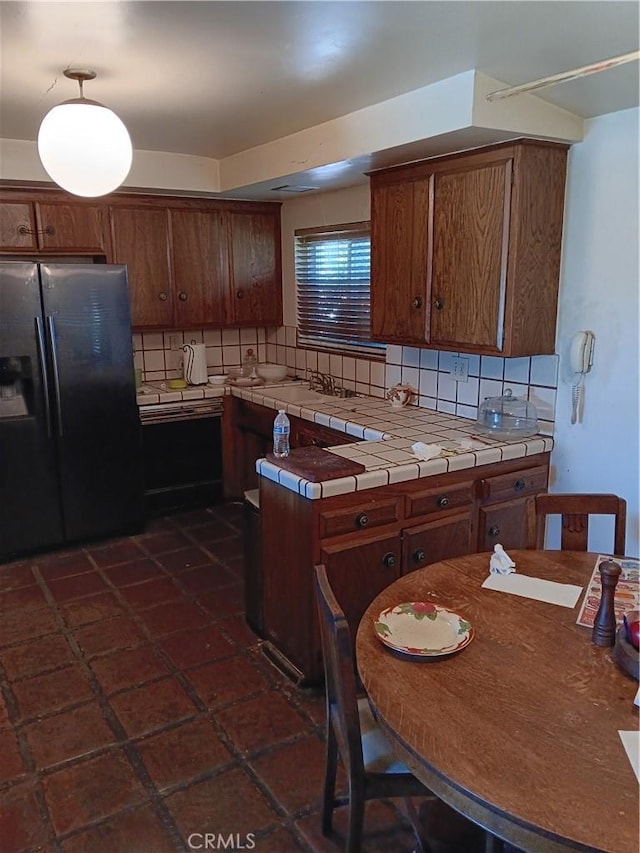 4301 Manson Ave, Woodland Hills, CA 91364 - kitchen featuring stainless steel fridge, tile counters, tasteful backsplash, and brown cabinets