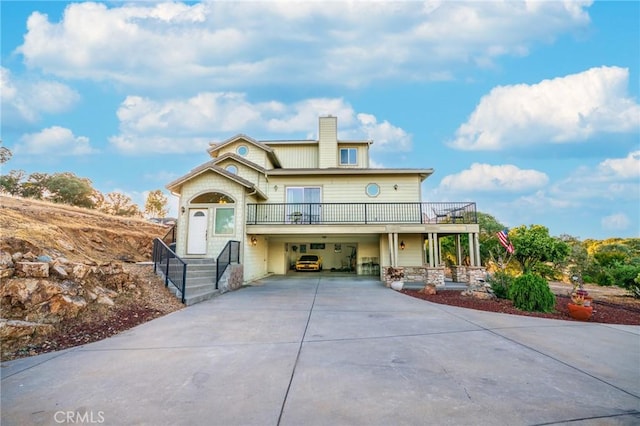 9713 Rastro Way, La Grange, CA 95329 - view of front of home featuring concrete driveway, an attached garage, a chimney, and a balcony