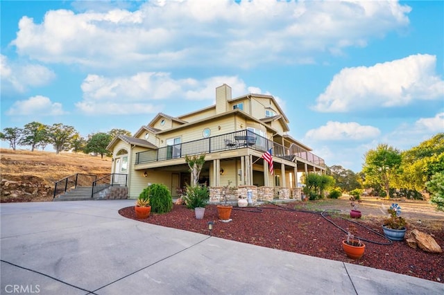 9713 Rastro Way, La Grange, CA 95329 - view of front facade with concrete driveway, a chimney, and a balcony