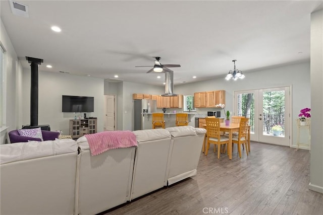 14868 Hickok Ct, Magalia, CA 95954 - living area featuring a ceiling fan, light wood finished floors, a wood stove, recessed lighting, and french doors