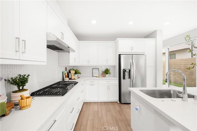 149 Carmine, Irvine, CA 92618 - kitchen featuring appliances with stainless steel finishes, under cabinet range hood, a sink, light countertops, and light wood-type flooring