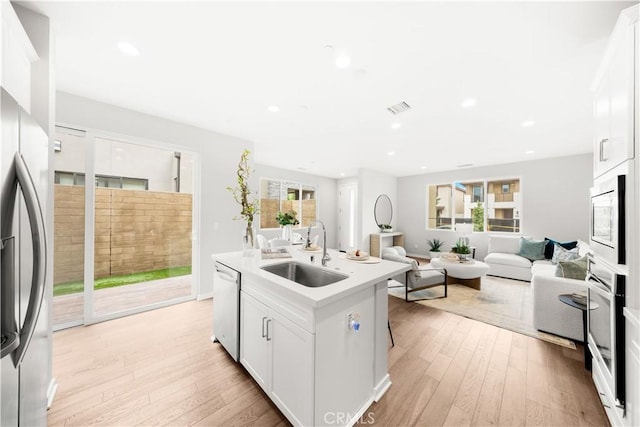 149 Carmine, Irvine, CA 92618 - kitchen featuring a sink, appliances with stainless steel finishes, open floor plan, light wood-style flooring, and white cabinetry