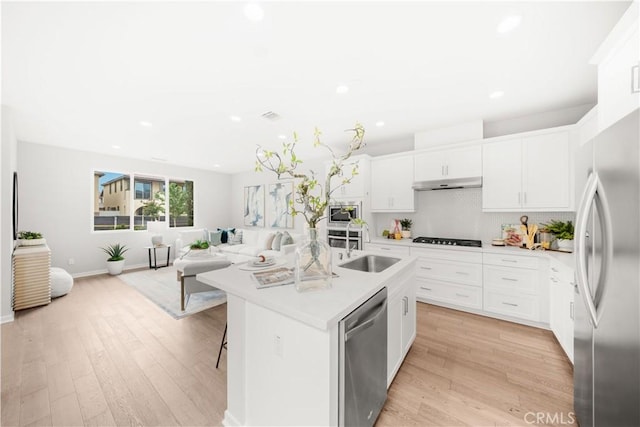 149 Carmine, Irvine, CA 92618 - kitchen featuring appliances with stainless steel finishes, under cabinet range hood, recessed lighting, light wood-type flooring, and light countertops