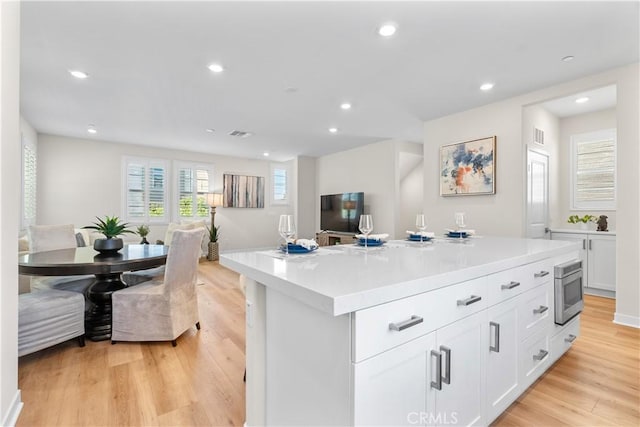 25 Splendor Way, Rancho Mission Viejo, CA 92694 - kitchen featuring recessed lighting, white cabinets, light wood-type flooring, light countertops, and a kitchen island
