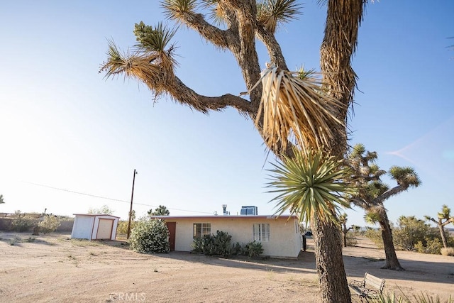 58382 Sunny Sands Dr, Yucca Valley, CA 92284 - view of side of home featuring stucco siding and a garage