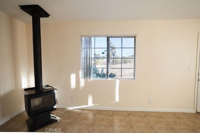 58382 Sunny Sands Dr, Yucca Valley, CA 92284 - unfurnished living room featuring a wood stove, baseboards, and tile patterned floors