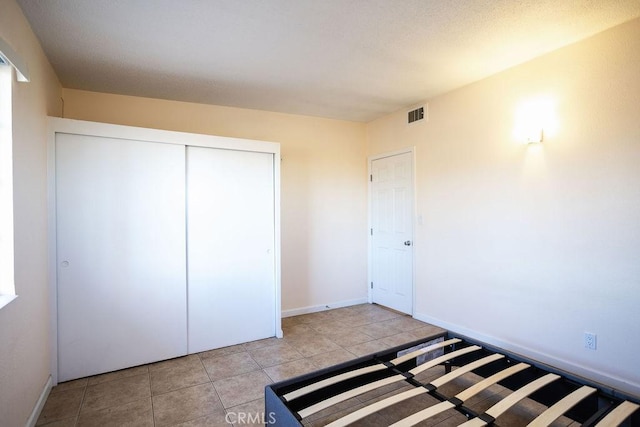 58382 Sunny Sands Dr, Yucca Valley, CA 92284 - unfurnished bedroom with a closet, light tile patterned flooring, and baseboards