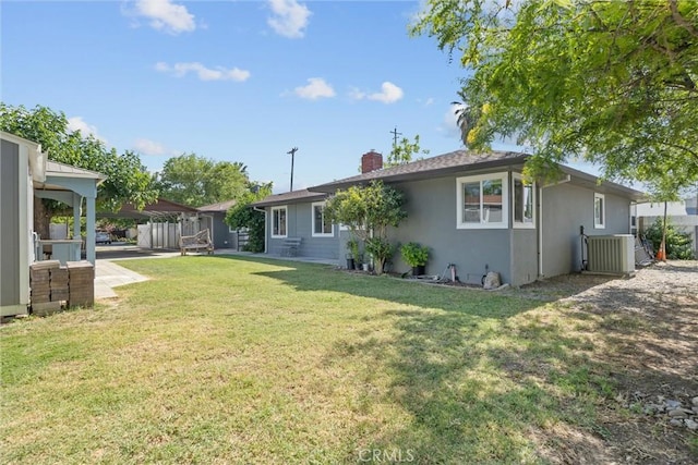 4436 County Road M 1/2, Orland, CA 95963 - back of house featuring a chimney, stucco siding, central AC unit, and a yard