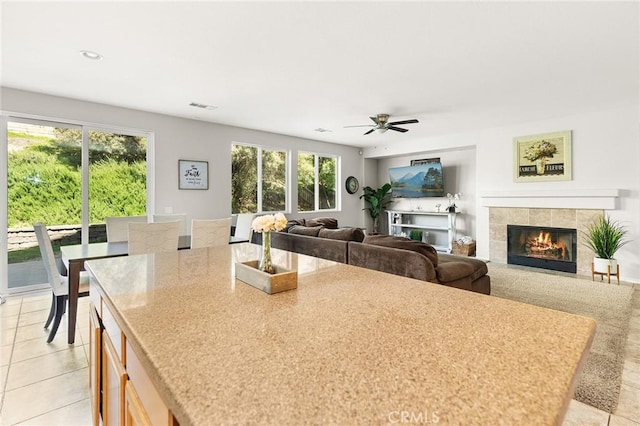 29778 Salmon St, Menifee, CA 92584 - kitchen with a tile fireplace, ceiling fan, light tile patterned floors, a kitchen island with sink, and recessed lighting