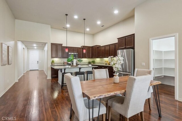 25863 Prospector Ct, Menifee, CA 92584 - dining space featuring a high ceiling, dark wood-style flooring, baseboards, and recessed lighting