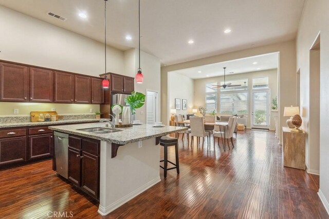 25863 Prospector Ct, Menifee, CA 92584 - kitchen with a sink, appliances with stainless steel finishes, light stone countertops, dark wood finished floors, and a breakfast bar area