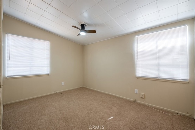 39026 11th St W, Palmdale, CA 93551 - spare room with healthy amount of natural light, carpet flooring, ceiling fan, lofted ceiling, and baseboards
