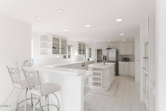 5331 Wavecrest Way, Oxnard, CA 93035 - kitchen featuring open shelves, stainless steel refrigerator with ice dispenser, a peninsula, an island with sink, and a sink