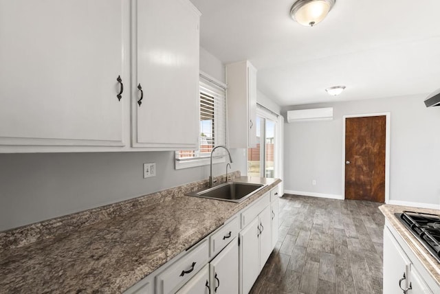 450 Dichter St, El Cajon, CA 92019 - kitchen featuring a sink, an AC wall unit, wood finished floors, white cabinetry, and stainless steel gas stovetop