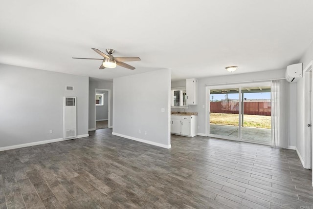 450 Dichter St, El Cajon, CA 92019 - unfurnished living room featuring a wall mounted AC, dark wood-style flooring, ceiling fan, baseboards, and a heating unit