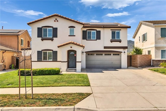 15040 Capstone St, Fontana, CA 92336 - mediterranean / spanish-style house featuring stucco siding, a tiled roof, a garage, and solar panels