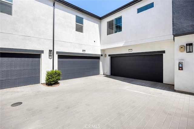3720 S Allston Paseo Unit 7, Ontario, CA 91761 - back of house featuring a garage, stucco siding, and driveway