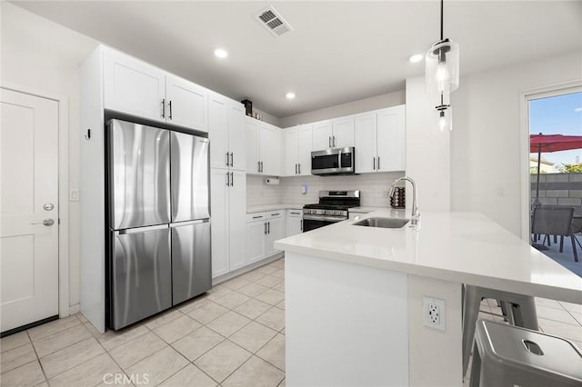 3720 S Allston Paseo Unit 7, Ontario, CA 91761 - kitchen featuring stainless steel appliances, a peninsula, a sink, white cabinets, and tasteful backsplash