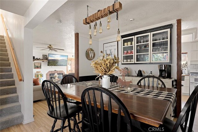 26249 Cedar Ln, Twin Peaks, CA 92391 - dining room with stairway, ceiling fan, light wood-type flooring, and a textured ceiling