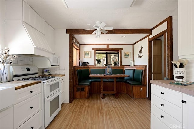 26249 Cedar Ln, Twin Peaks, CA 92391 - kitchen featuring white appliances, light wood-style floors, ceiling fan, white cabinetry, and decorative backsplash