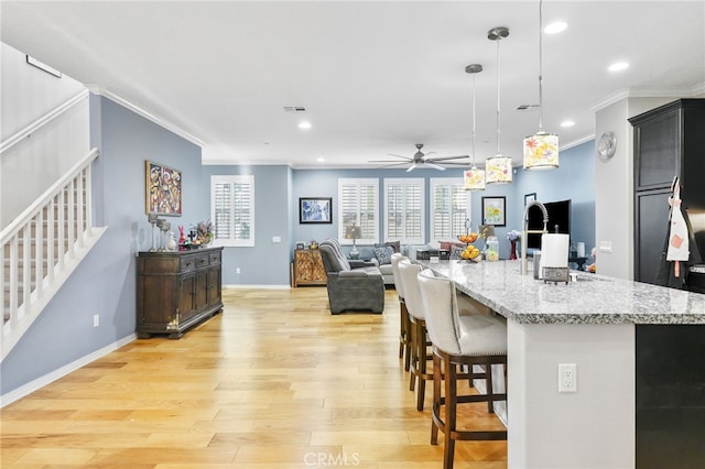22124 Barrington Way, Saugus, CA 91350 - kitchen featuring crown molding, a ceiling fan, a kitchen bar, light wood-style flooring, and recessed lighting