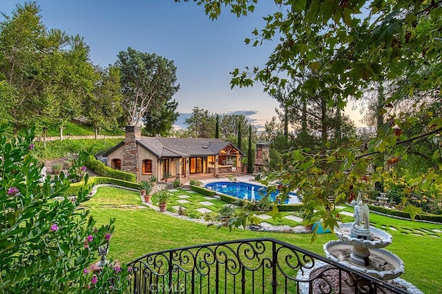 31742 Contijo Way, Coto De Caza, CA 92679 - back of property at dusk with a yard, an outdoor pool, and a chimney