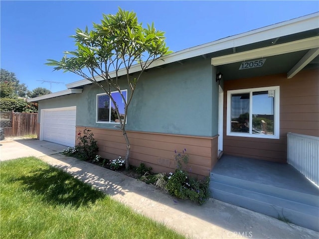 12055 Mount Vernon Ave, Grand Terrace, CA 92313 - view of side of property with a garage, driveway, and stucco siding