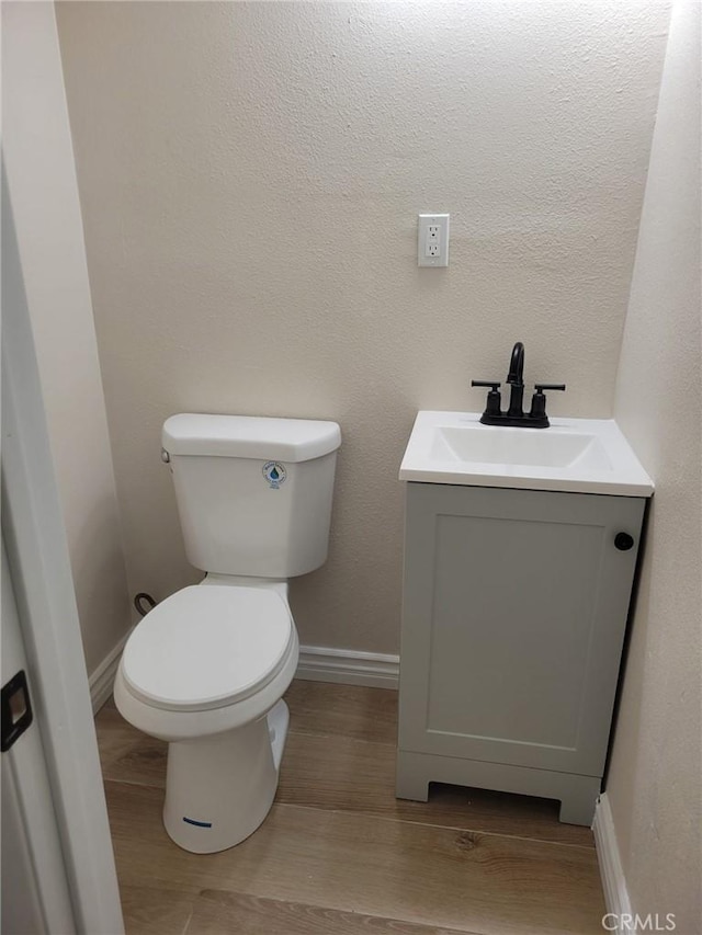 12055 Mount Vernon Ave, Grand Terrace, CA 92313 - bathroom featuring vanity, toilet, wood finished floors, and baseboards