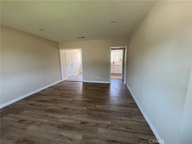 12055 Mount Vernon Ave, Grand Terrace, CA 92313 - empty room featuring dark wood-style floors, baseboards, and a sink