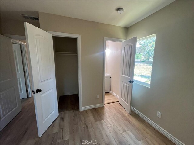 12055 Mount Vernon Ave, Grand Terrace, CA 92313 - unfurnished bedroom featuring wood finished floors, baseboards, a closet, and a spacious closet