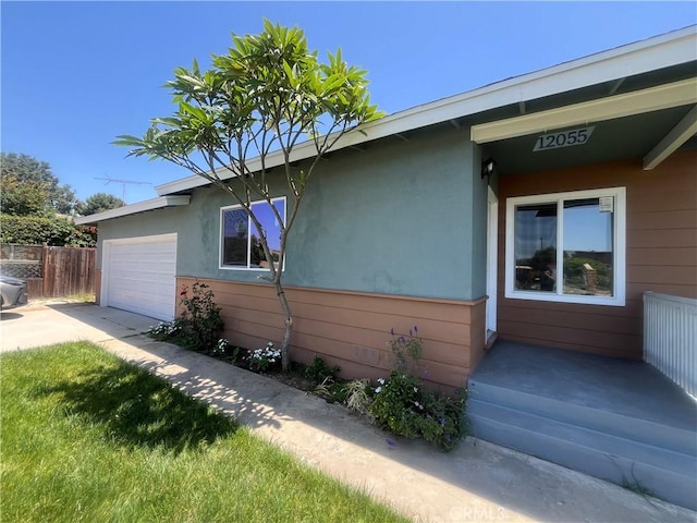 12055 Mount Vernon Ave, Grand Terrace, CA 92313 - view of side of home with an attached garage, concrete driveway, and stucco siding