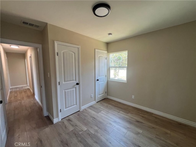 12055 Mount Vernon Ave, Grand Terrace, CA 92313 - unfurnished bedroom featuring wood finished floors, baseboards, and multiple closets