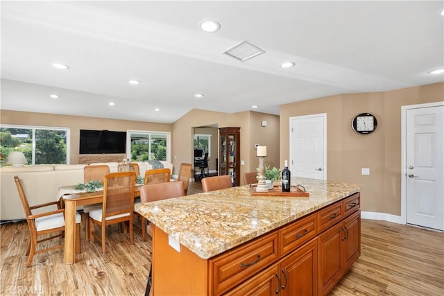 28052 Espinoza, Mission Viejo, CA 92692 - kitchen featuring light wood-style flooring, light stone counters, a center island, recessed lighting, and baseboards