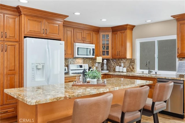 28052 Espinoza, Mission Viejo, CA 92692 - kitchen featuring white refrigerator with ice dispenser, stainless steel dishwasher, brown cabinets, a sink, and light stone countertops