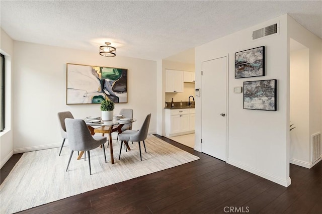849 E Victoria St Unit 210, Carson, CA 90746 - dining space with dark wood finished floors, a textured ceiling, and baseboards