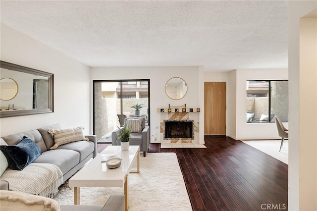 849 E Victoria St Unit 210, Carson, CA 90746 - living area with healthy amount of natural light, dark wood-style flooring, a fireplace with flush hearth, and a textured ceiling