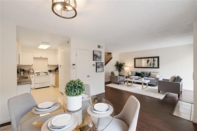 849 E Victoria St Unit 210, Carson, CA 90746 - dining area with light wood finished floors, stairway, and baseboards