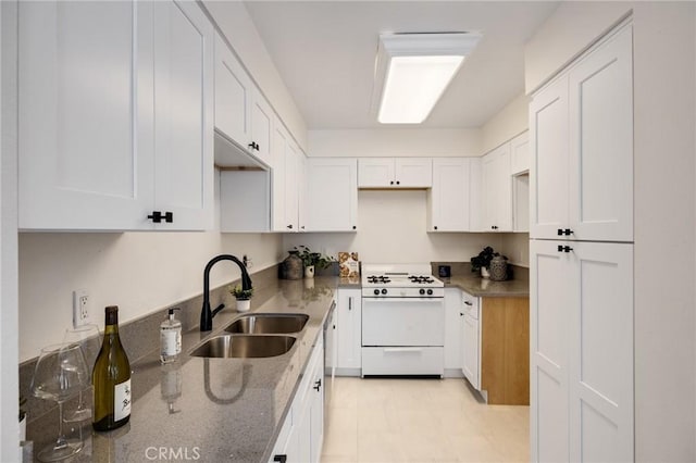849 E Victoria St Unit 210, Carson, CA 90746 - kitchen featuring a sink, white gas range oven, dark stone countertops, and white cabinetry