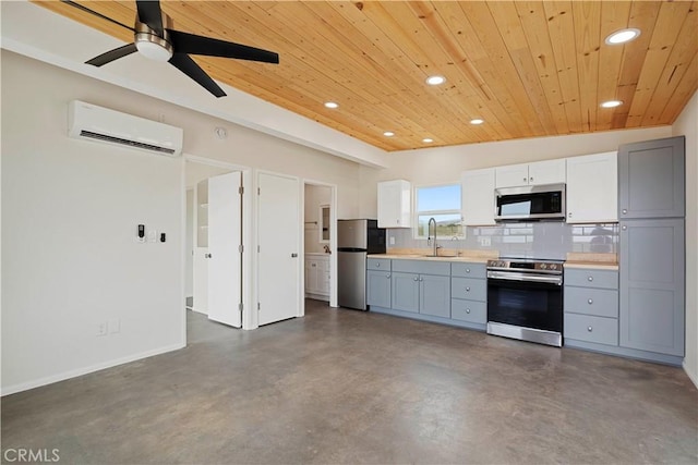 57628 Pine St, Landers, CA 92285 - kitchen featuring appliances with stainless steel finishes, an AC wall unit, wood ceiling, a sink, and recessed lighting