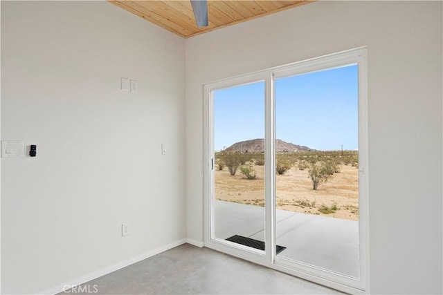 57628 Pine St, Landers, CA 92285 - doorway to outside featuring a mountain view, baseboards, wood ceiling, and concrete flooring