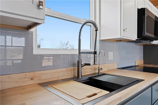 57628 Pine St, Landers, CA 92285 - kitchen featuring white cabinetry, backsplash, light countertops, and healthy amount of natural light