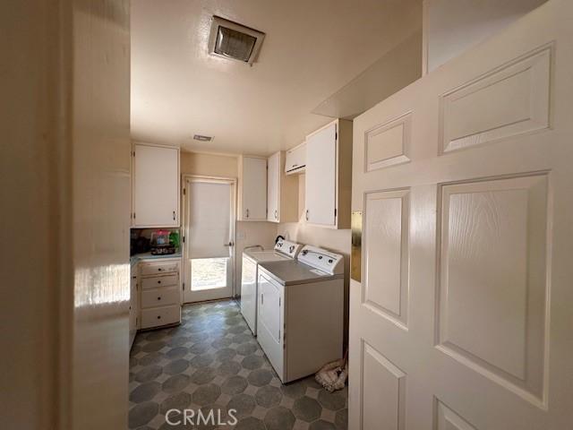 2968 Mill Creek Rd, Mentone, CA 92359 - washroom with washer and dryer, cabinet space, and dark flooring