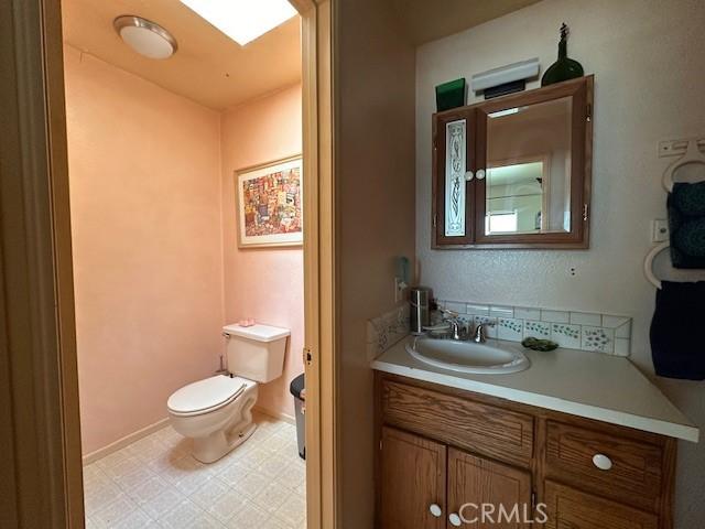 2968 Mill Creek Rd, Mentone, CA 92359 - half bathroom with toilet, vanity, and tile patterned floors
