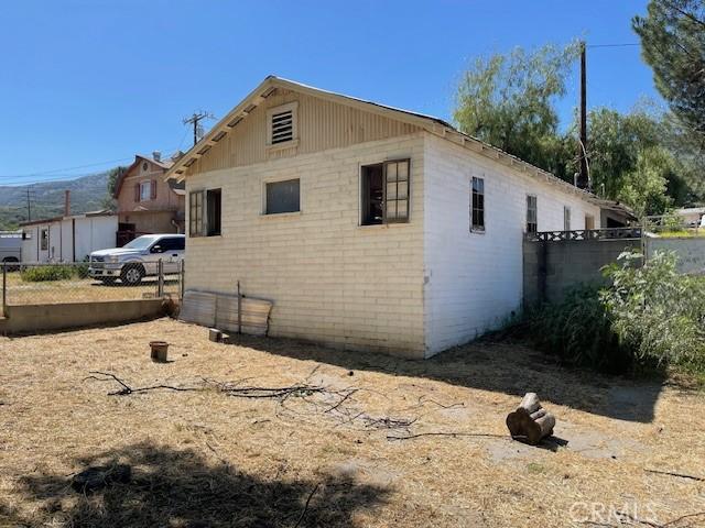 2968 Mill Creek Rd, Mentone, CA 92359 - view of side of home with brick siding