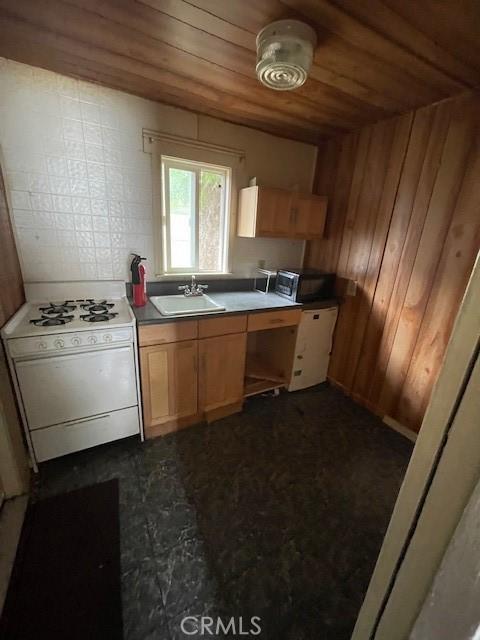 2968 Mill Creek Rd, Mentone, CA 92359 - kitchen featuring white gas stove, a sink, wooden ceiling, and wooden walls